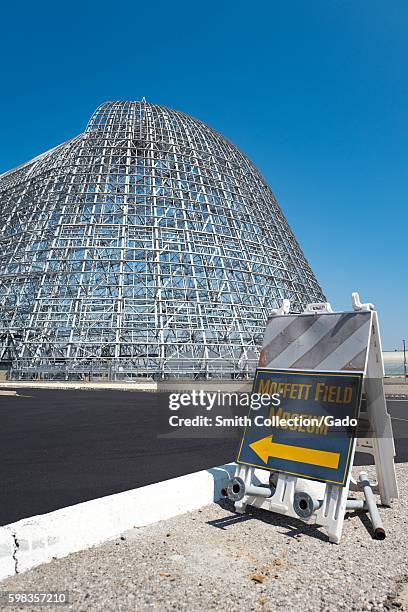 Sign with arrow directing visitors to the Moffett Field Historical Museum, with Hangar One visible in the background, within the secure area of the...