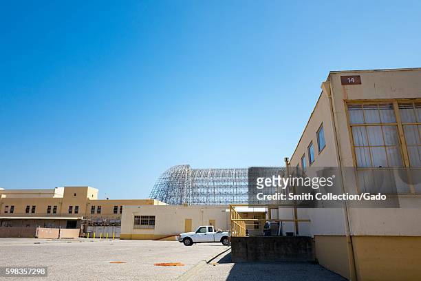 The exposed metal frame of Hanger One is visible behind building 14 within the secure area of the NASA Ames Research Center campus in the Silicon...