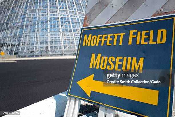 Sign with arrow directing visitors to the Moffett Field Historical Museum, with Hangar One visible in the background, within the secure area of the...