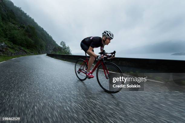 female race cyclist driving down mountain road - cycling bicycle sports race stock pictures, royalty-free photos & images