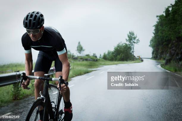male race cyclist driving up mountain road - ciclismo fotografías e imágenes de stock