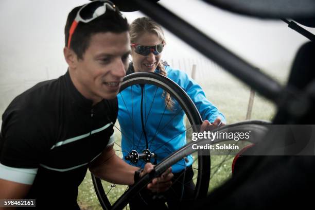 cyclist couple packing gear into car - motorized sport bildbanksfoton och bilder
