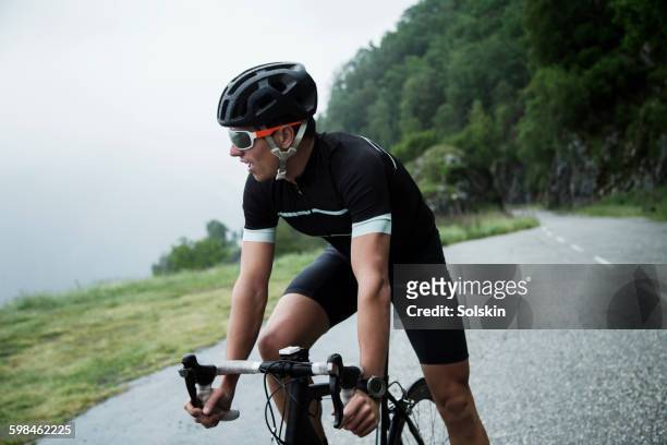 male race cyclist resting by mountain road - men's cycling stock pictures, royalty-free photos & images