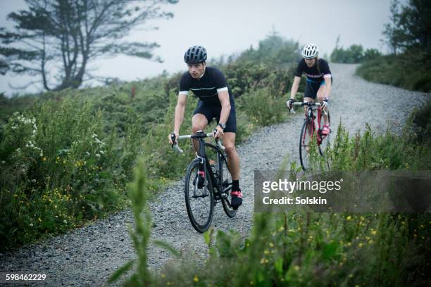 cross cycling man and woman on dirt road - norway womens training session stock pictures, royalty-free photos & images