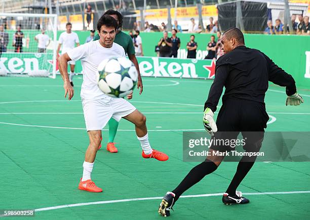 Sergio Perez of Mexico and Force India shoots past Dida of Brazil during the Heineken Champions of the Grid Charity football match during previews...