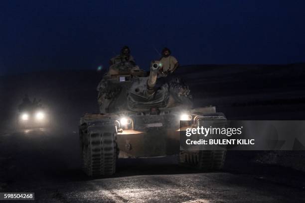 Turkish soldiers stand in a Turkish army tank driving back to Turkey from the Syrian-Turkish border town of Jarabulus on September 1, 2016 in the...