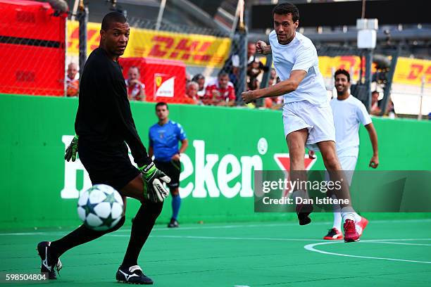 Jolyon Palmer of Great Britain and Renault Sport F1 takes a shot past Dida of Brazil during the Heineken Champions of the Grid Charity football match...