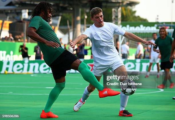Max Verstappen of Netherlands and Red Bull Racing and Christian Karembeu of France stretch for the ball during the Heineken Champions of the Grid...