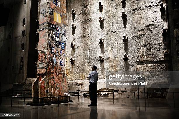 Visitor to the 9/11 Memorial Museum looks up at the last foundation pillar that was standing from the World Trde Center site on September 01, 2016 in...