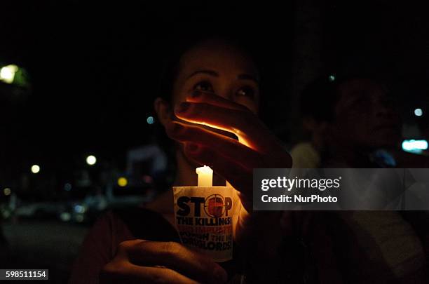 Filipino activist holds a candle for the victims of extrajudicial killings during a demonstration at the Sto. Domingo Church in Quezon City, east of...