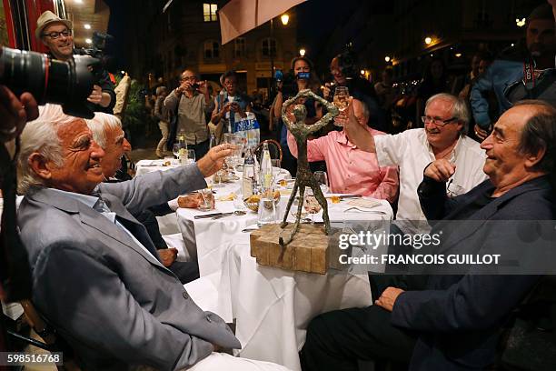 French actor Jean-Paul Belmondo raises his glass next to French actor Charles Gerard and French and Senegalese actor Richard Bohringer after being...