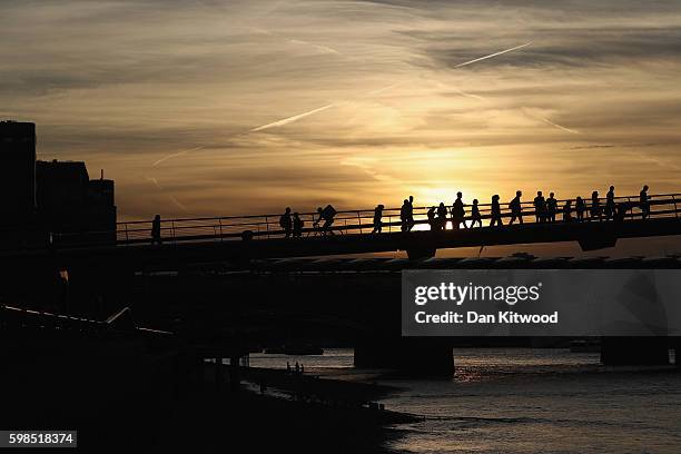 The sunt sets over the River Thames as installations are lit in front of Tate Modern as part of the 'Fire Garden' event by Compagnie Carabosse on...