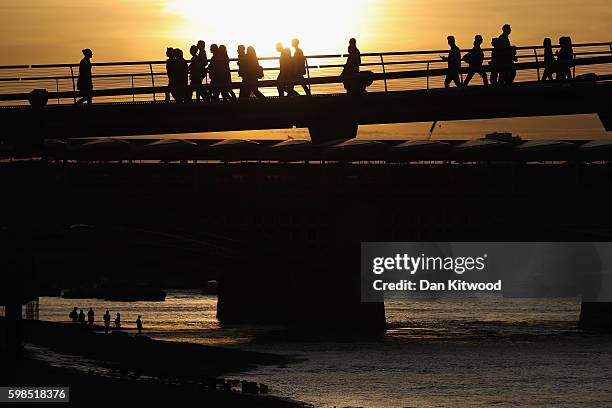 The sun sets over the River Thames as installations are lit in front of Tate Modern as part of the 'Fire Garden' event by Compagnie Carabosse on...