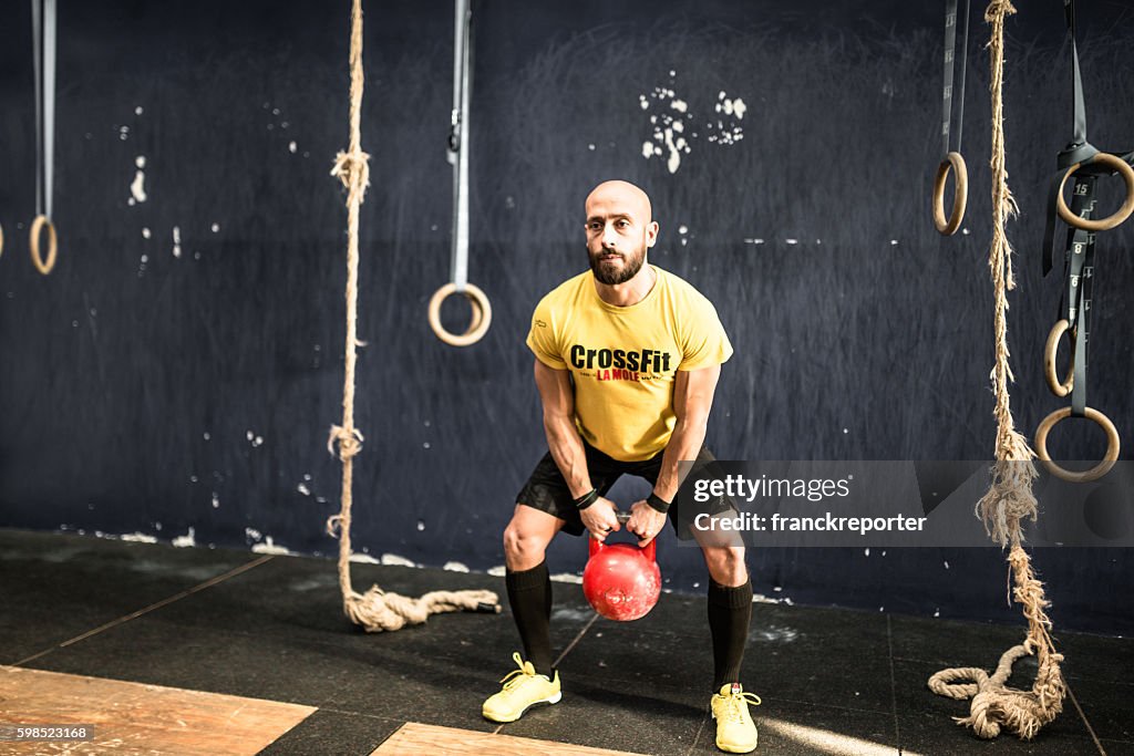 Man using the kettlebell on the gym