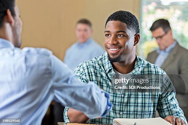 hübscher junger afroamerikanischer mann bei vorstellungsgespräch - african american interview stock-fotos und bilder