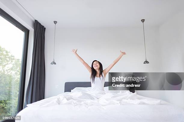 donna asiatica sbadigliando a letto - materasso foto e immagini stock