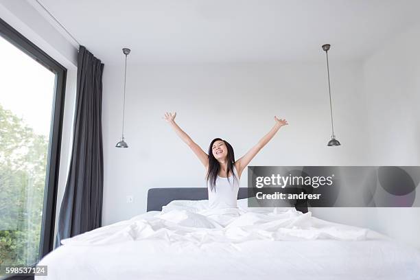 asian woman yawning in bed - mattress stock pictures, royalty-free photos & images