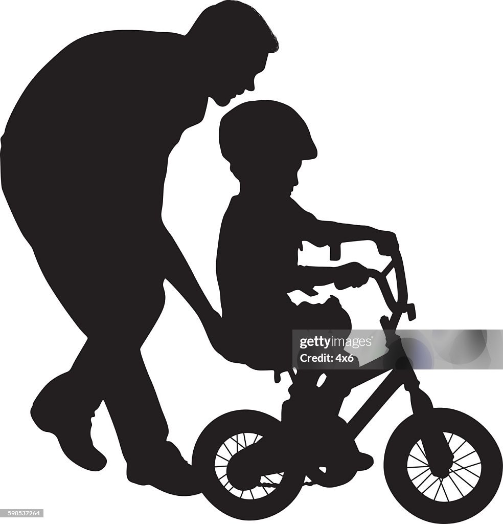 Father helping his child to ride bicycle