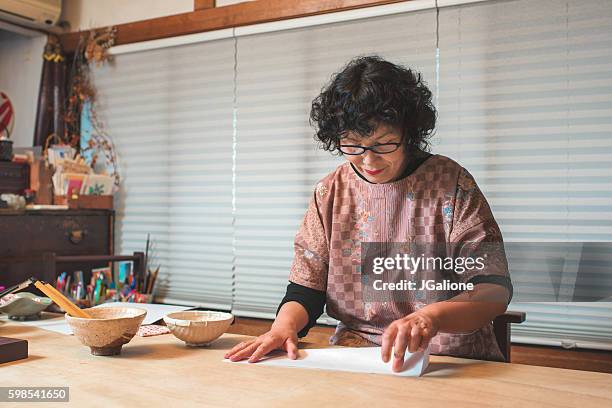 senior japanese woman folding craft paper - papier stock pictures, royalty-free photos & images