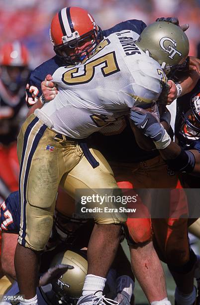 Joe Burns of the Georgia Tech Yellow Jackets tacklesmoves with the ball as Mark Holtzman of the Syracuse Orangemen tries to tackle him during the...