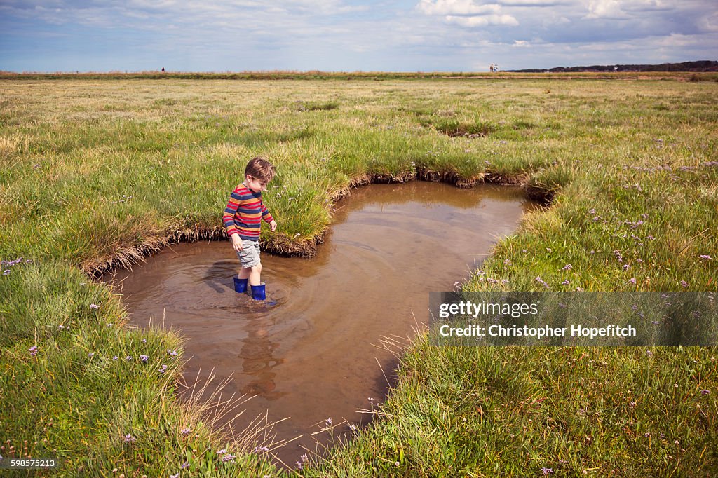 Young boy wading through a pool
