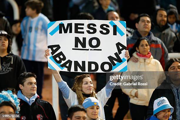 Woman shows a placard that reads in spanish 'Messi Doesn't Abandon' during a match between Argentina and Uruguay as part of FIFA 2018 World Cup...