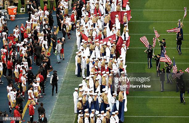 Colin Kaepernick of the San Francisco 49ers on the sidelines as military personel line up before the singing of the National Anthem before a...