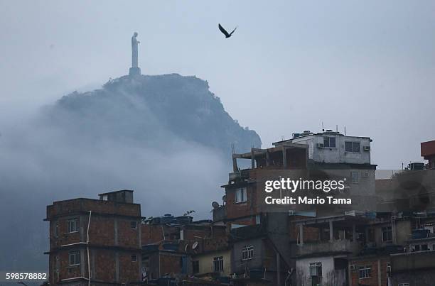 Christ the Redeemer statue stands above the Cantagalo 'favela' community on September 1, 2016 in Rio de Janeiro, Brazil. The city is set to host the...