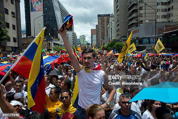 Opposition supporters hold Venezuelan flags and sing the national anthem during a protest in Caracas, Venezuela, on Thursday, Sept. 1, 2016....
