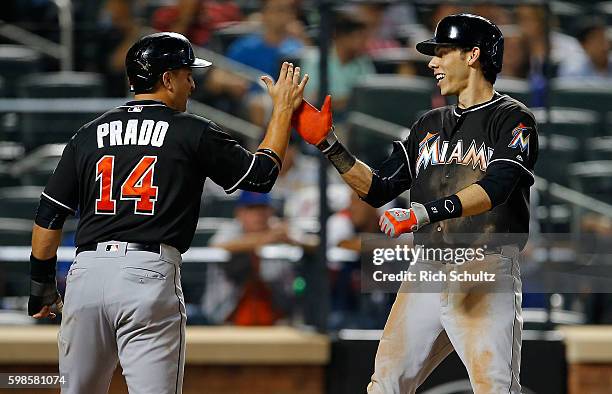 Christian Yelich of the Miami Marlins is congratulated by Martin Prado after hitting a three-run home run in the seventh inning against the New York...