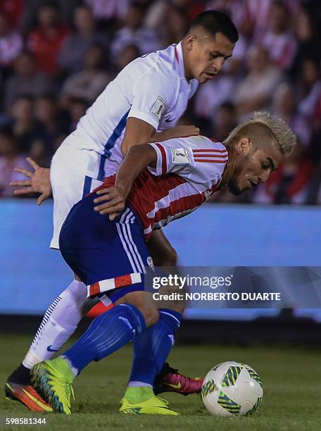 Chile's Alexis Sanchez vies for the ball with Paraguay's Victor Ayala during their FIFA World Cup 2018 qualifier football match in Asuncion,...