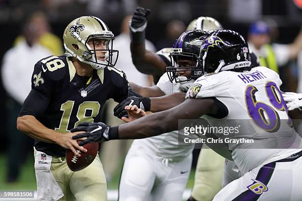 Garrett Grayson of the New Orleans Saints is tackled by Willie Henry of the Baltimore Ravens at the Mercedes-Benz Superdome on September 1, 2016 in...
