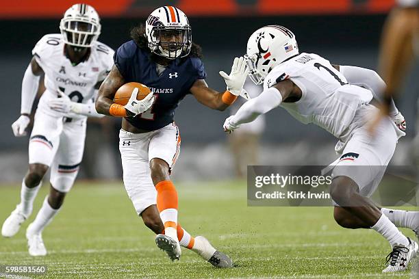 Najee Ray of the Tennessee-Martin Skyhawks stiff-arms Tyrell Gilbert of the Cincinnati Bearcats while carrying the ball during the third quarter at...