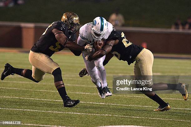 Glen Cuiellette of the Tulane Green Wave is tackled by Duke Ejiofor and Thomas Brown of the Wake Forest Demon Deacons at BB&T Field on September 1,...