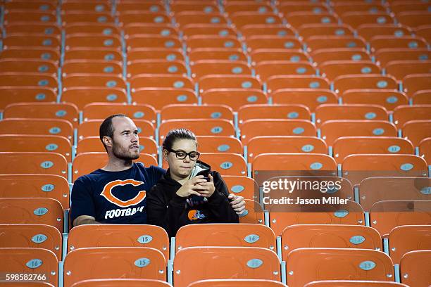 Chicago Bears fan and a Cleveland Browns fan wait out the end of the game during the fourth quarter at FirstEnergy Stadium during a preseason game on...