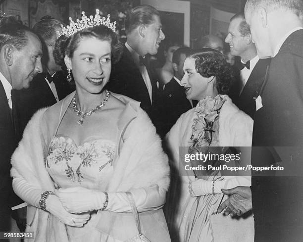 Queen Elizabeth II wearing an evening dress and tiara as she arrives at the Royal premiere of the film 'Neapolitan Fantasy', followed by Princess...