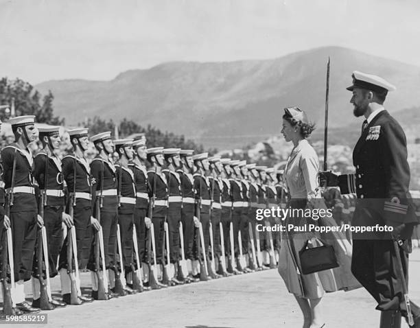 Queen Elizabeth II, accompanied by the Guard Commander inspecting a Guard of Honour at Prince's Wharf, Hobart, during the Commonwealth tour of...