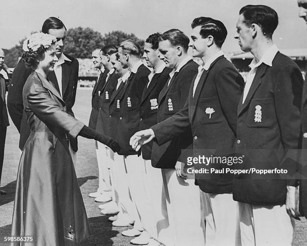 Queen Elizabeth II is introduced to England fast bowler Fred Truman by captain Peter May as she meets the England Cricket Team prior to play on the...