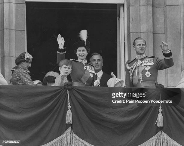 Queen Elizabeth II wears a tricorne hat with the plume of the Grenadiers, as she waves from the balcony of Buckingham Palace with the Duke of...