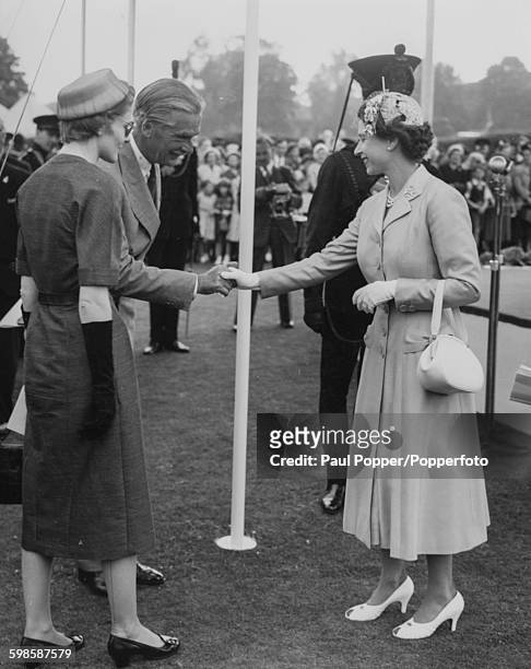 Queen Elizabeth II shakes hands with Prime Minister Sir Anthony Eden at a bicentenary celebration and inspection of the King's Royal Rifle Corps,...
