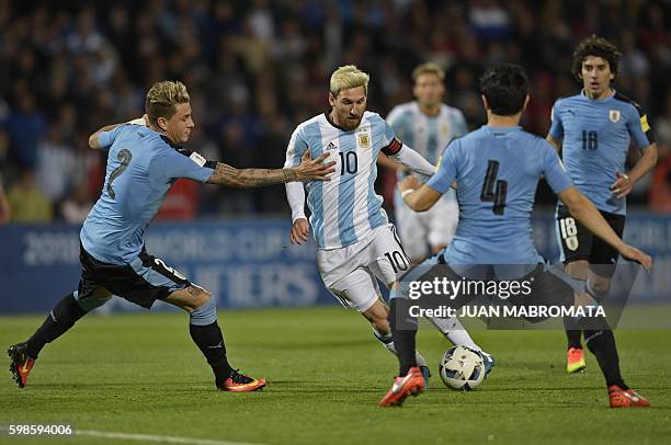 Argentina's Lionel Messi vies for the ball with Uruguay's Jose Maria Gimenez and Uruguay's Jorge Fucile during the Russia 2018 World Cup qualifier...