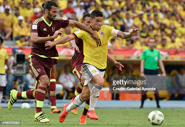 James Rodriguez of Colombia struggles for the ball with Oswaldo Vizcarrondo of Venezuela during a match between Colombia and Venezuela as part of...