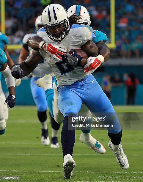 Derrick Henry of the Tennessee Titans is forced out of bounds by Neville Hewitt of the Miami Dolphins during a preseason game at Hard Rock Stadium on...