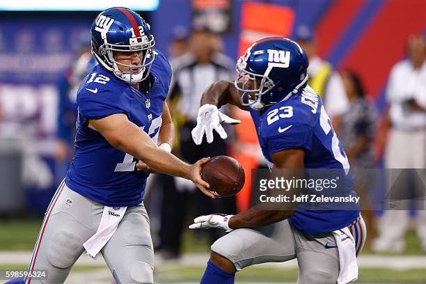 Ryan Nassib hands off to Rashad Jennings of the New York Giants during their preseason game against the New England Patriots at MetLife Stadium on...