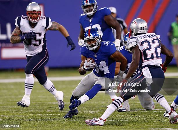 Shane Vereen of the New York Giants runs the ball into Justin Coleman of the New England Patriots during their preseason game at MetLife Stadium on...