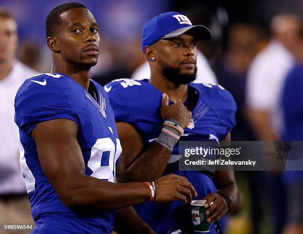 Victor Cruz and Shane Vereen of the New York Giants stand on the sidelines against the New England Patriots during their preseason game at MetLife...