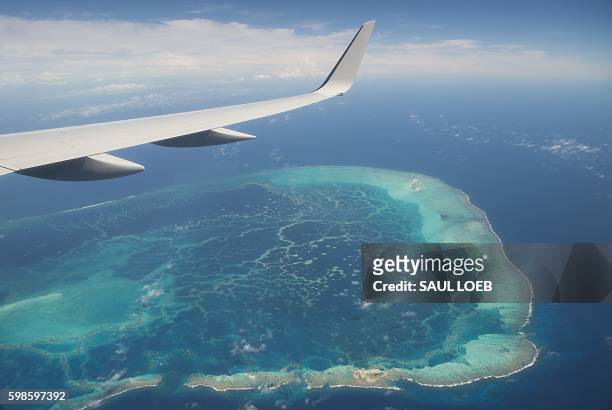 The view out the window of Air Force One, with US President Barack Obama aboard, over a nearby island as the airplane approaches Midway Atoll in the...