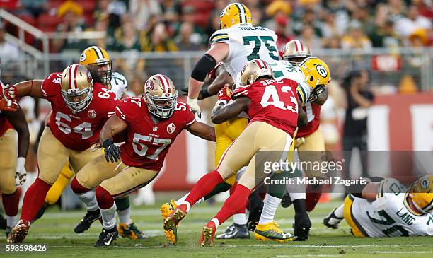 Michael Wilhoite and Chris Davis of the San Francisco 49ers tackle James Starks of the Green Bay Packers during the game at Levi Stadium on August...
