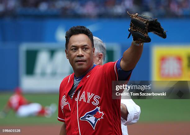 Hall of Fame player Roberto Alomar of the Toronto Blue Jays acknowledges fans after catching a ceremonial first pitch from former general manager and...