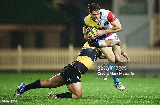 Seb Wileman of the Rays is tackled by Ben Tapuai of the Spirit during the round two NRC match between the Sydney Rays and the Perth Spirit at North...